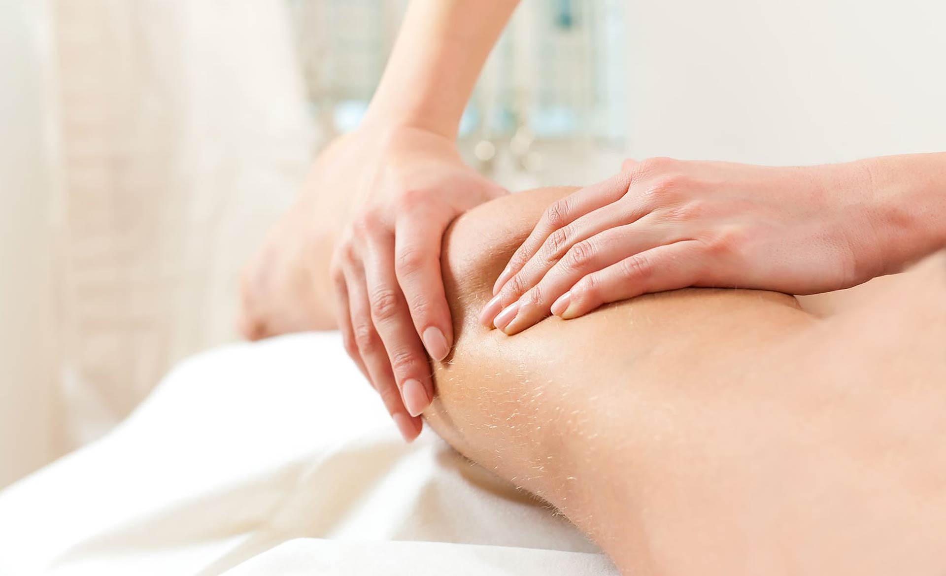 Hands performing a sports massage on a client's calf
