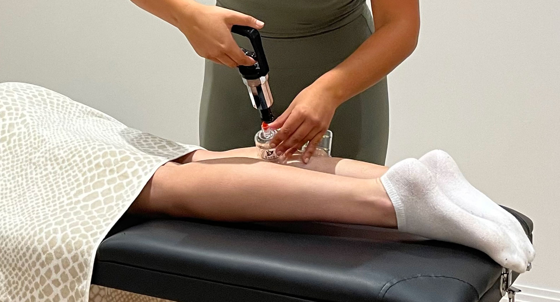 Ellis applying a dry cupping set to a client's leg