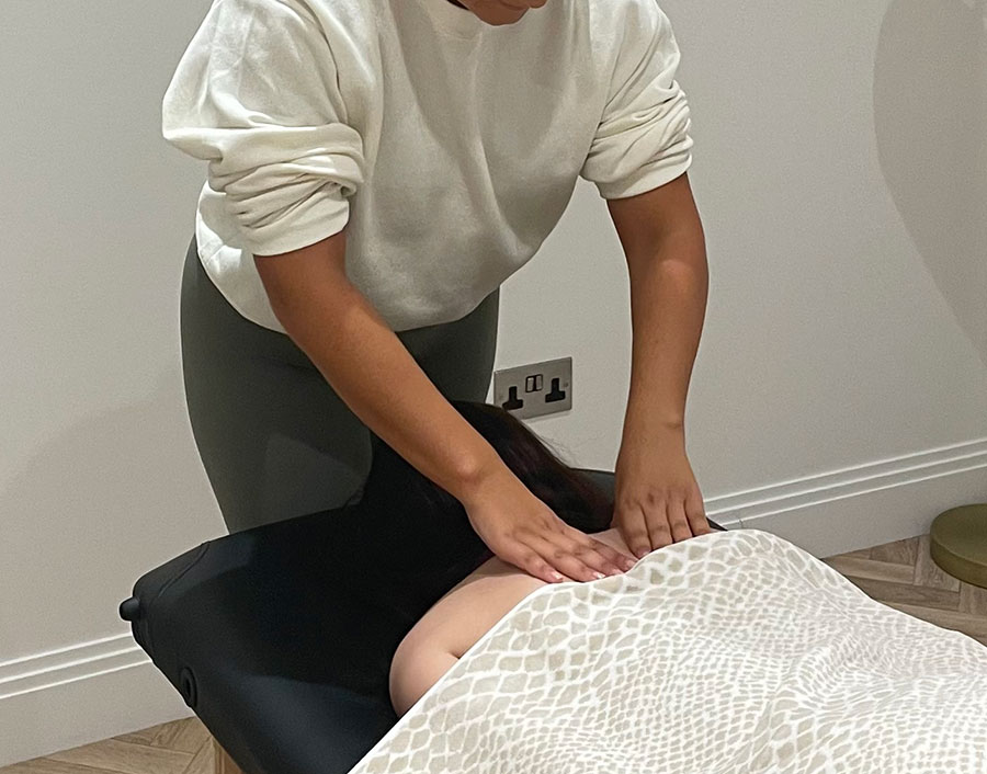Ellis performing deep tissue massage on a client's upper back